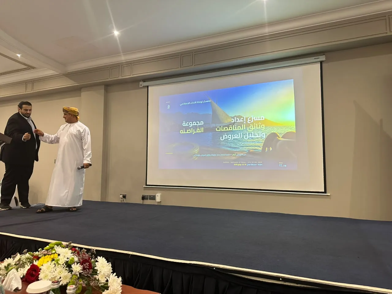 A participant presents a group project on stage at the AI Nukhatha boot camp in Salalah